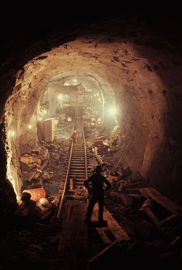 Мужчины взрывают гранит в тунеле, чтобы построить гидроэлектростанцию в Австралии, 1963 