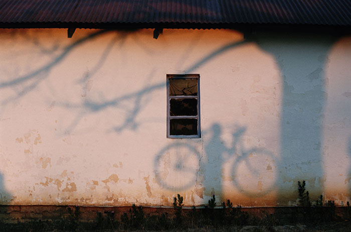 Тень мужчины, который несет велосипед возле реки Замбези, 1996 год