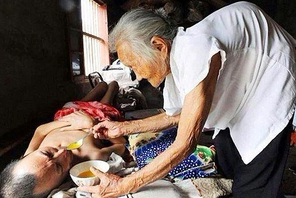 90-летняя мать ухаживает за своим 60-летним парализованным сыном. Она кормит его уже 19 лет.