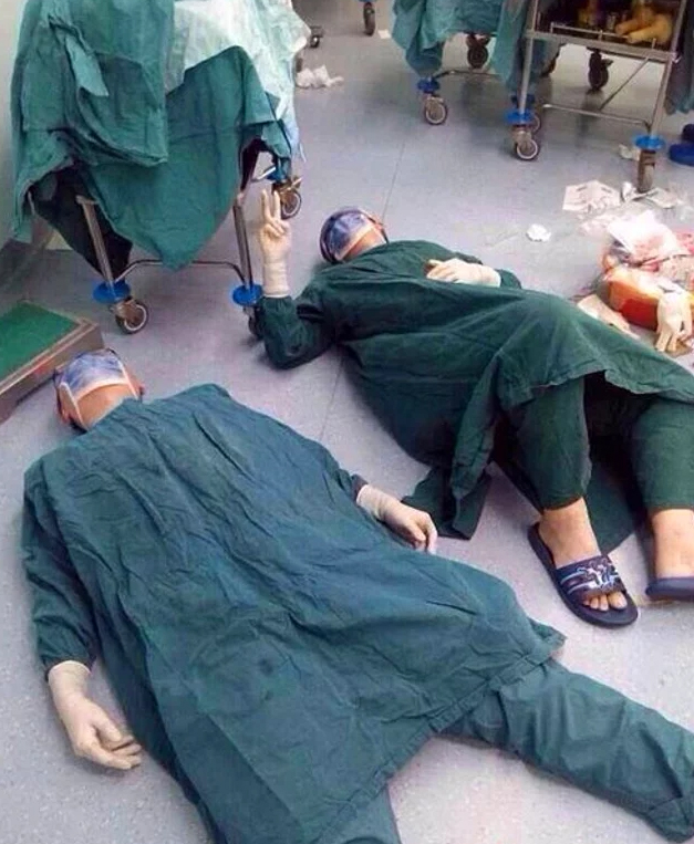 Врачи лежат на полу после 32-часовой операции по удалению группы опухолей головного мозга у одного пациента